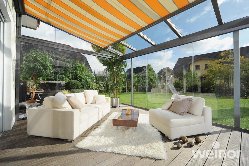 A living room with a couch and a table under a striped awning.