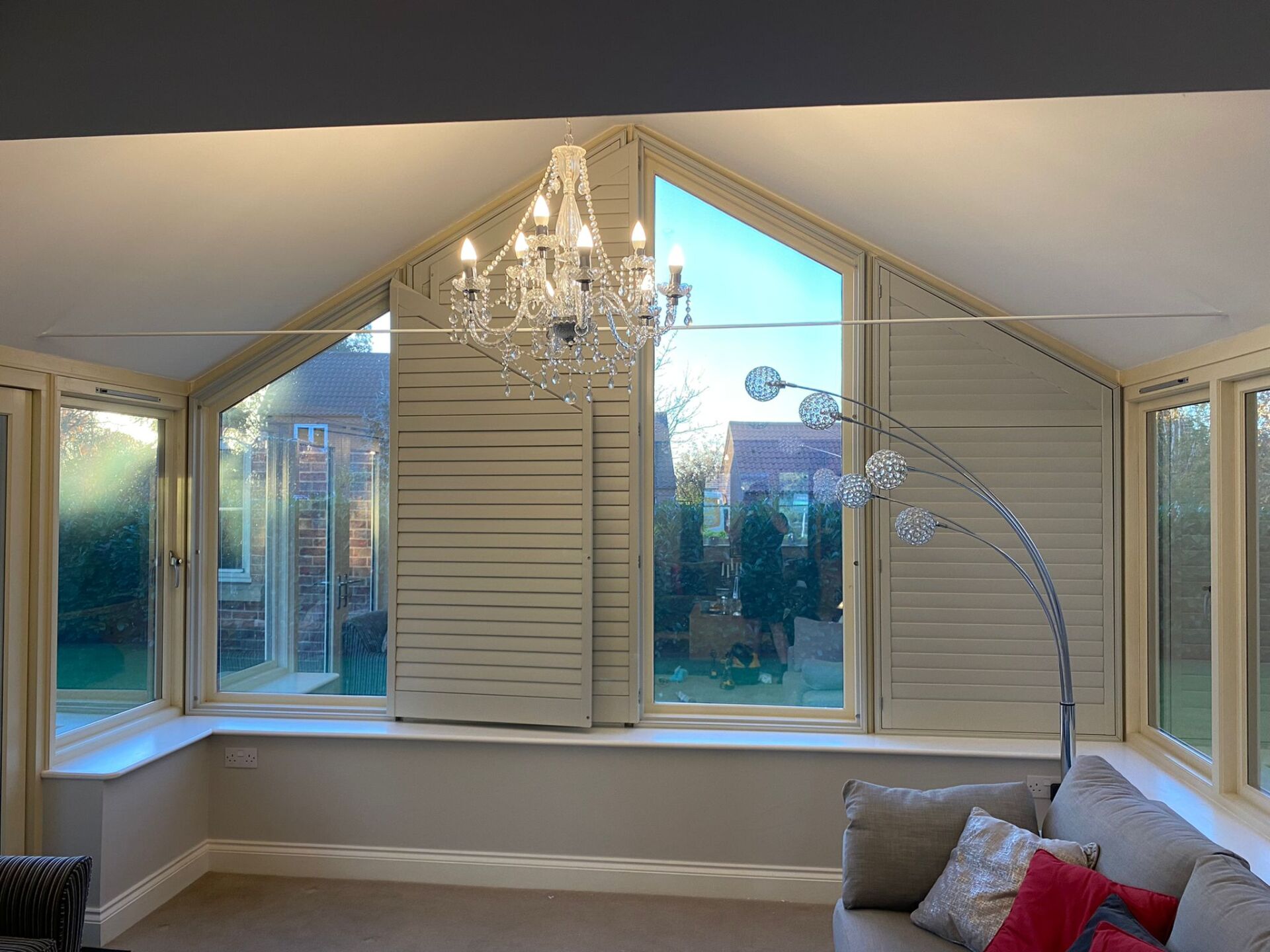 A living room with a couch and a chandelier.
