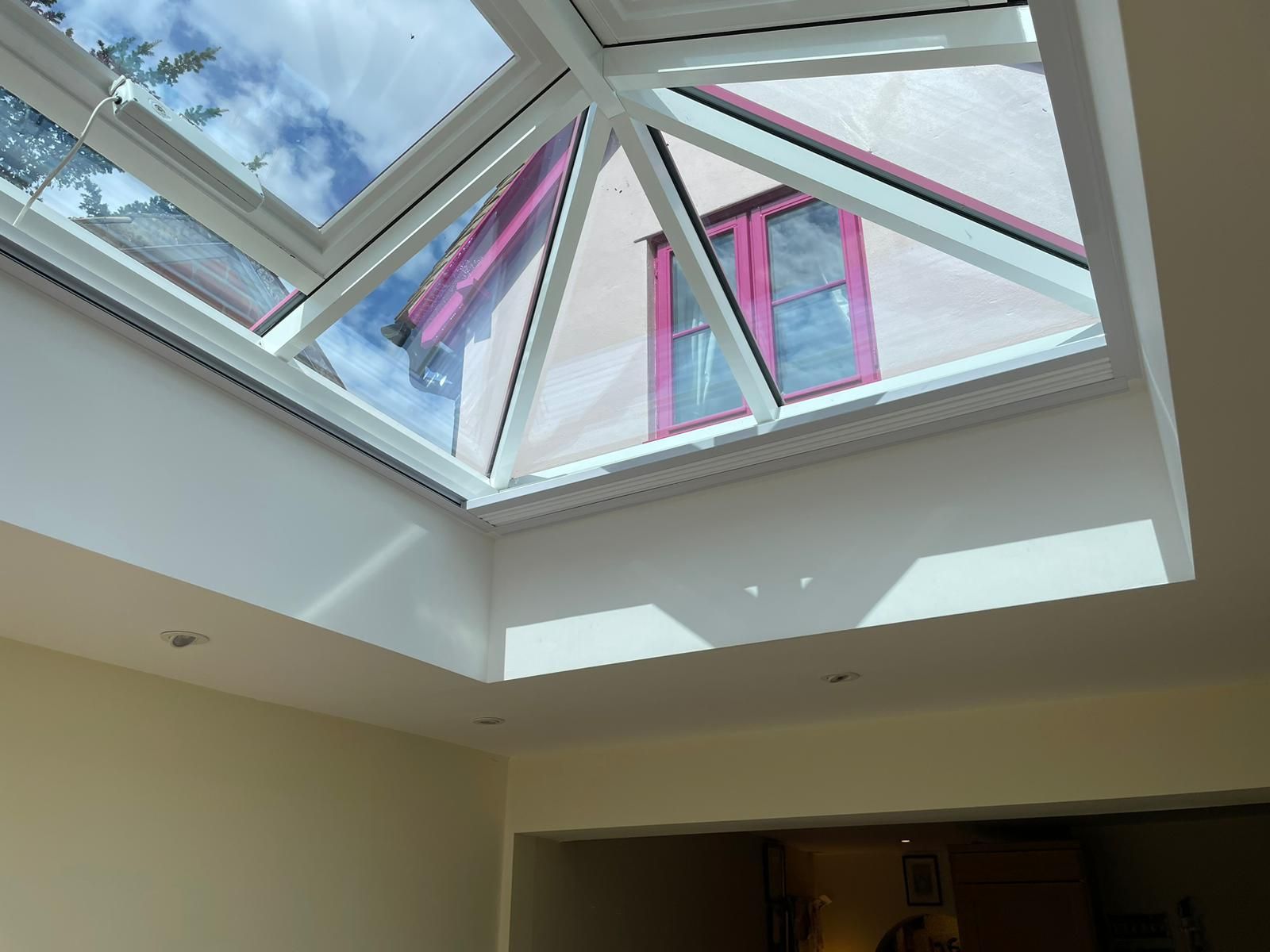 A room with a skylight and a pink window