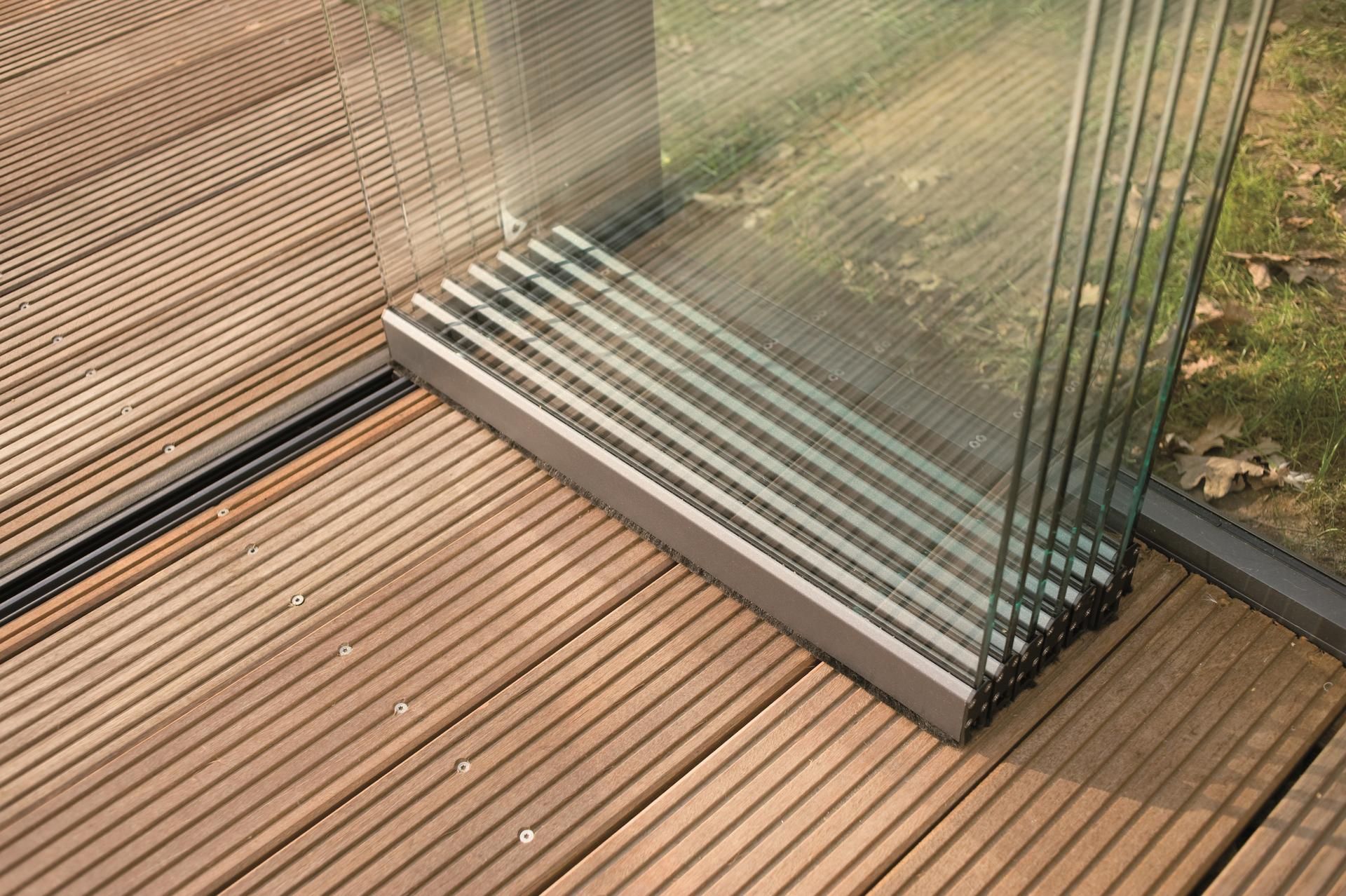 A sliding glass door is sitting on a wooden deck.