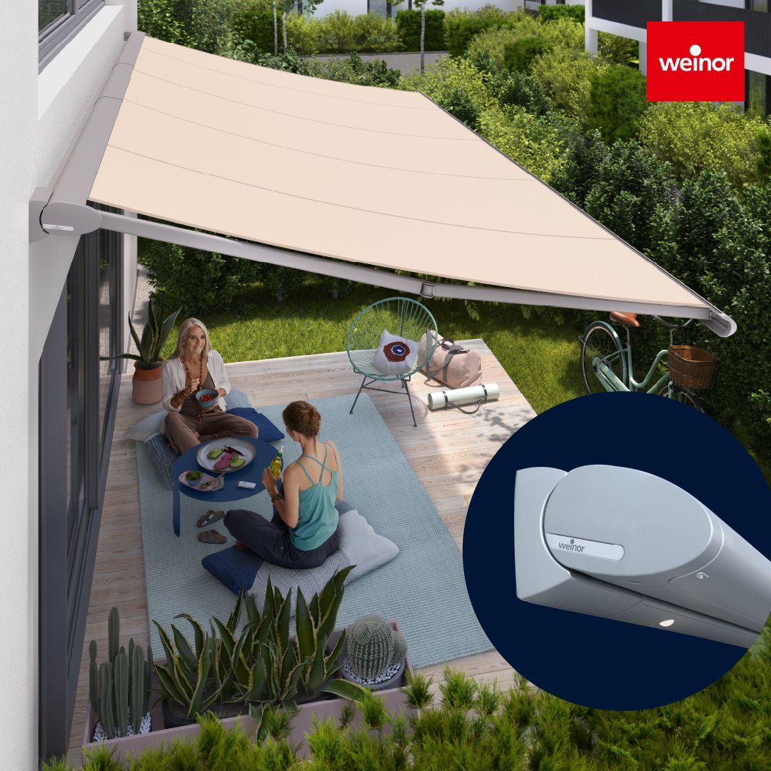 A group of people are sitting under an awning on a patio.