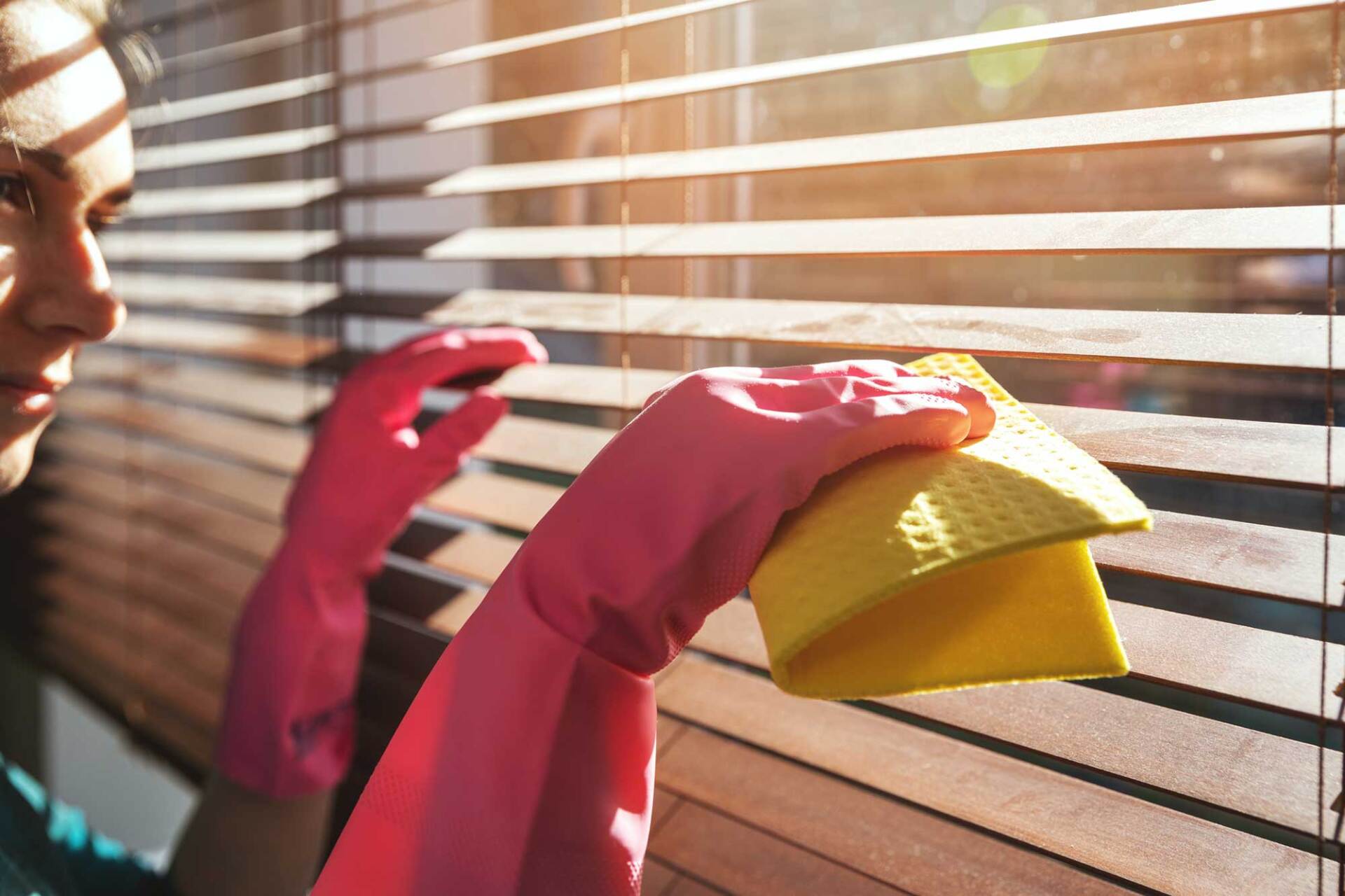 Woman Cleaning Wooden Window Blinds — St. Louis, MO — Overland Shade Co.