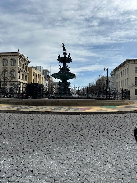 A fountain in the middle of a cobblestone street