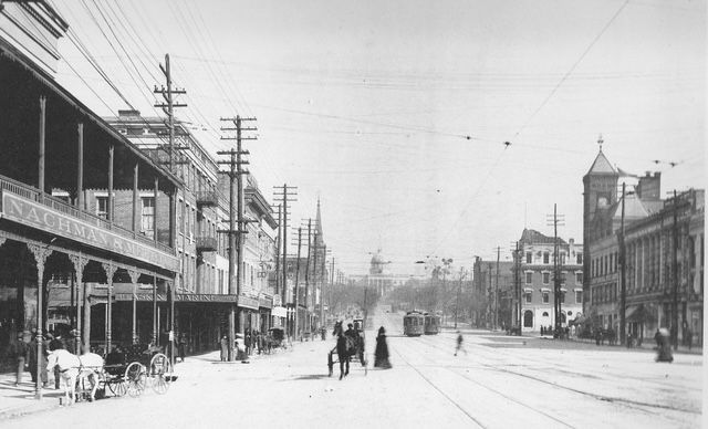 A black and white photo of montgomery alabama dexter avenue with horse drawn carriages.