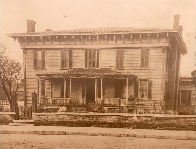 A black and white photo of the first white house of the confederacy, a large house with a porch.