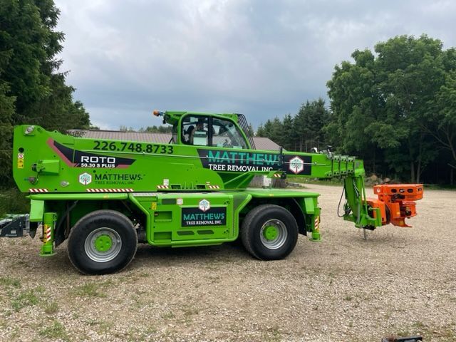 A tree being cut down by a crane in the snow