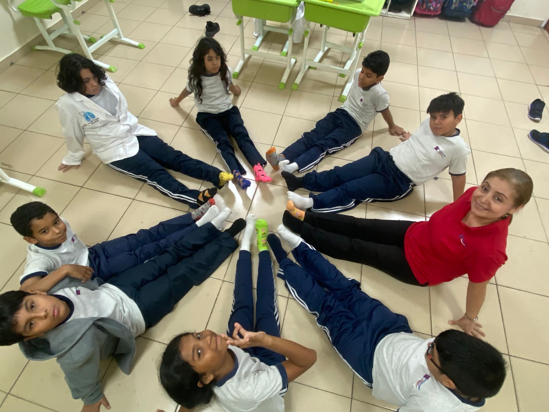 Dinámica de integración grupal con estudiantes formando una estrella en el aula del CEI Montessori.