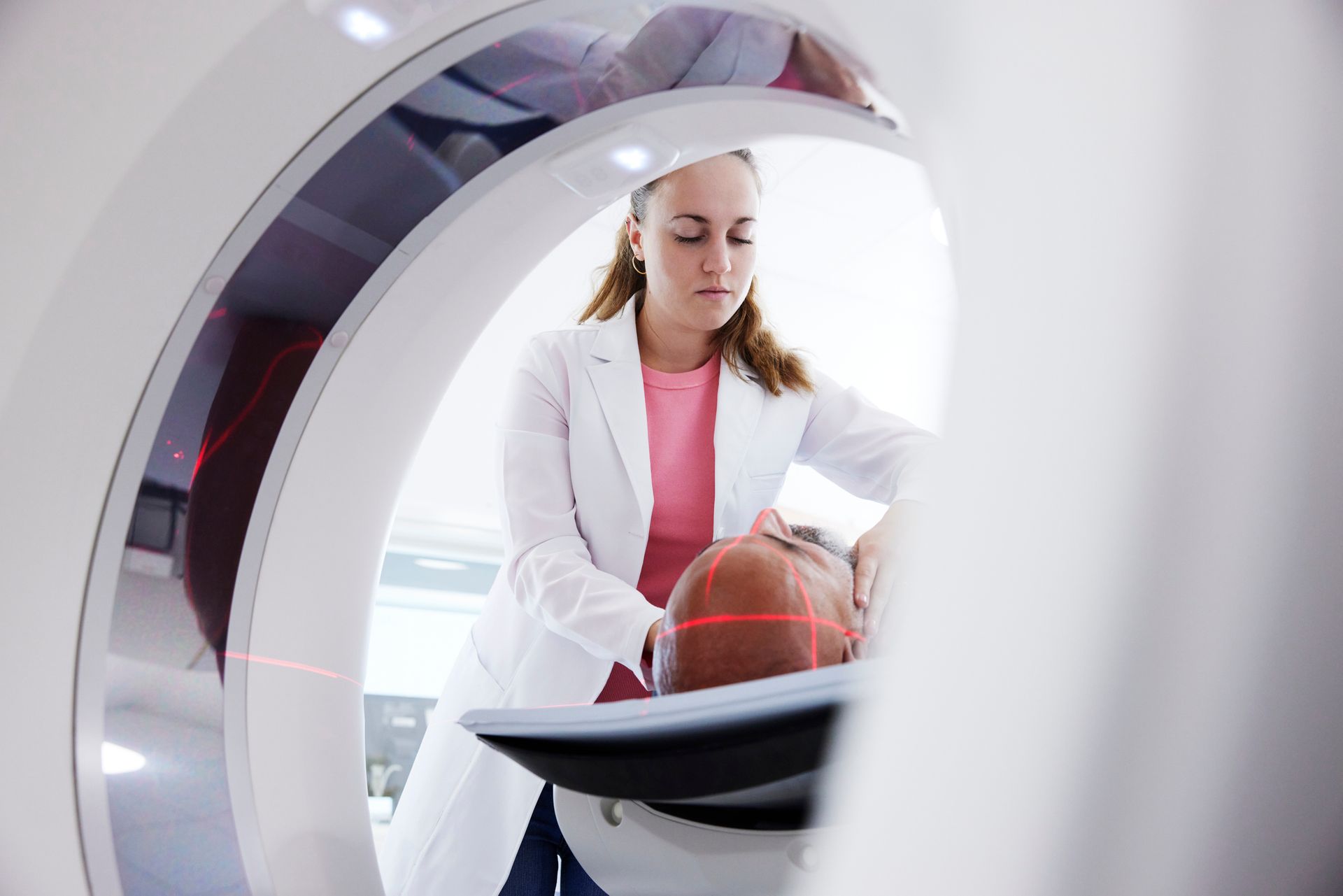 Female radiologist helping patient in medical x-ray scanner.