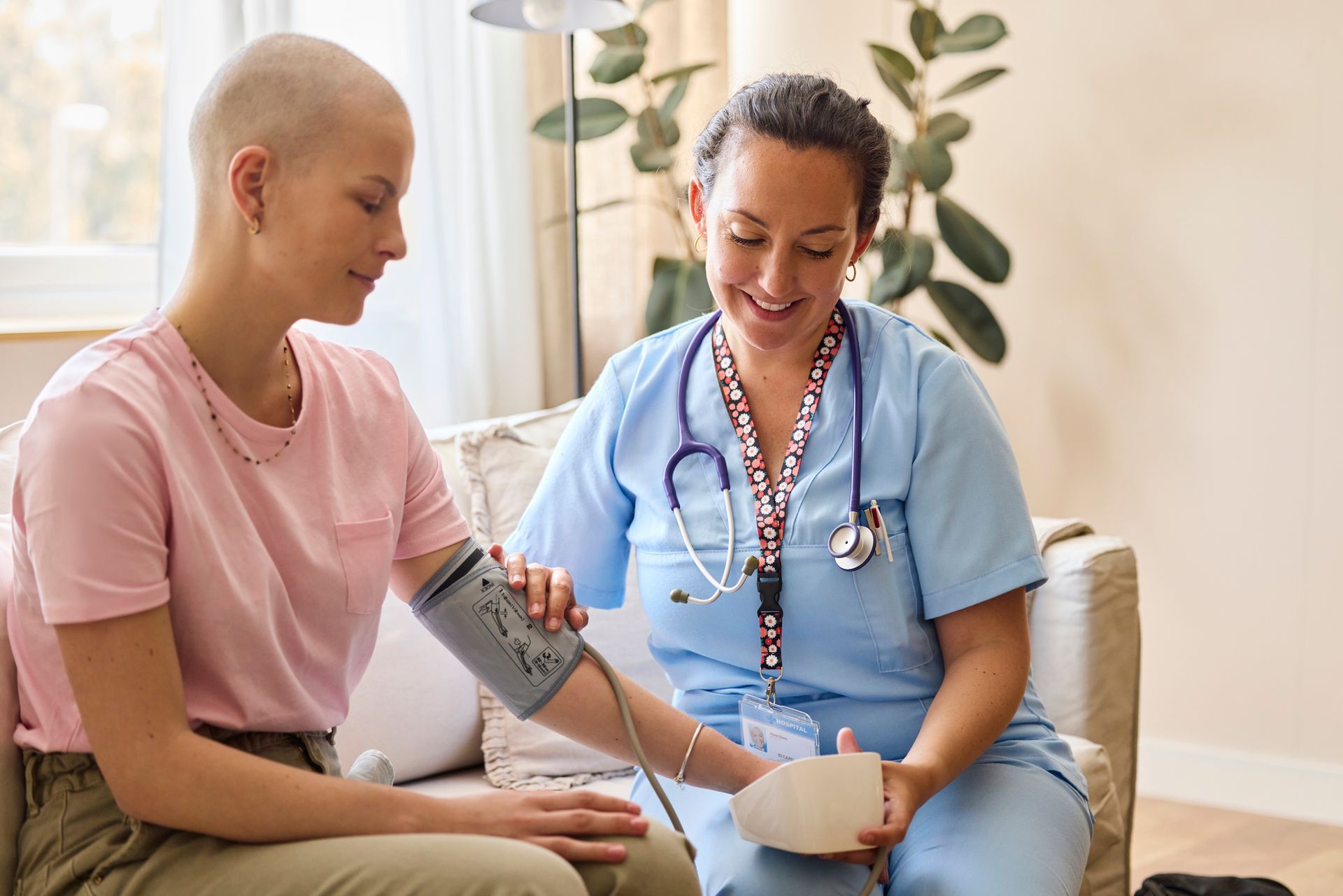 Healthcare worker checking blood pressure of woman.