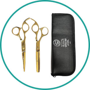 A pair of gold scissors next to a black case