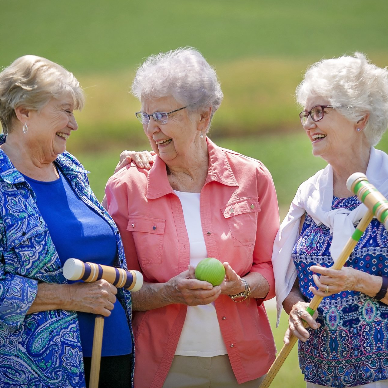 Senior ladies chatting while playing croquet in the Landmark Commons lawn space