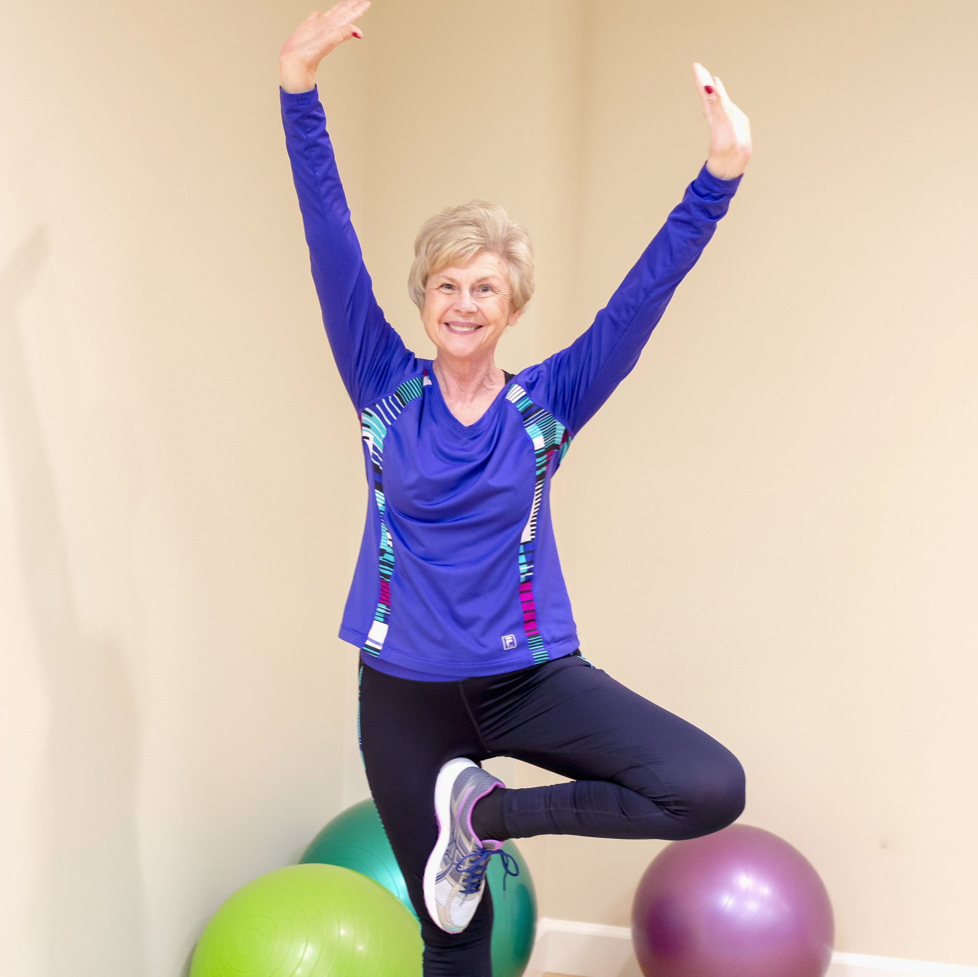 senior woman practicing balance during her yoga class in the fitness center of Landmark Commons