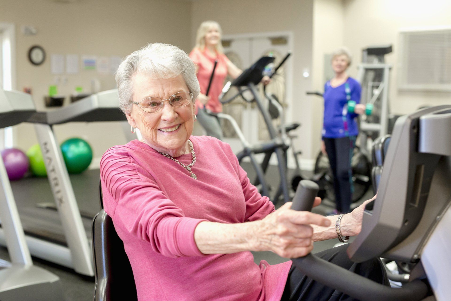 Retired lady exercising on a seated bike in the fitness center