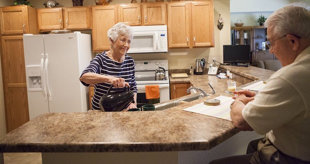 resident pouring coffee in her independent living apartment