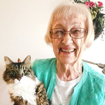 Independent senior lady holding her cat in her apartment at Friendship Village