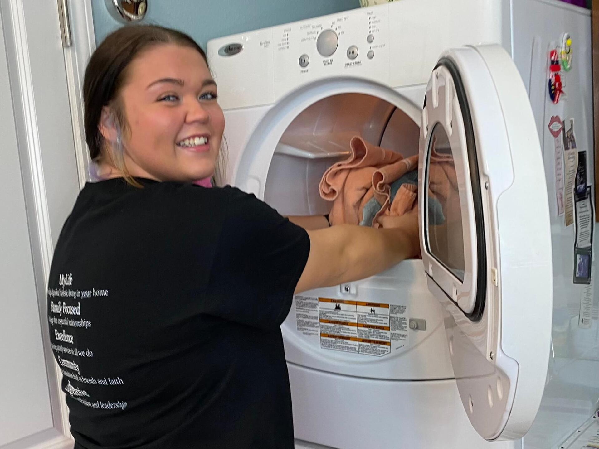 Friends At Home employee assisting resident with laundry services