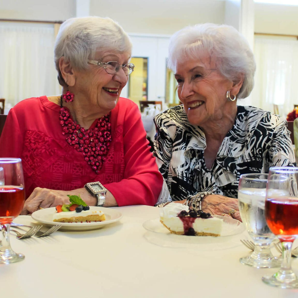 Independent, retired ladies socializing and enjoying dessert and wine in Friendship Village dining room
