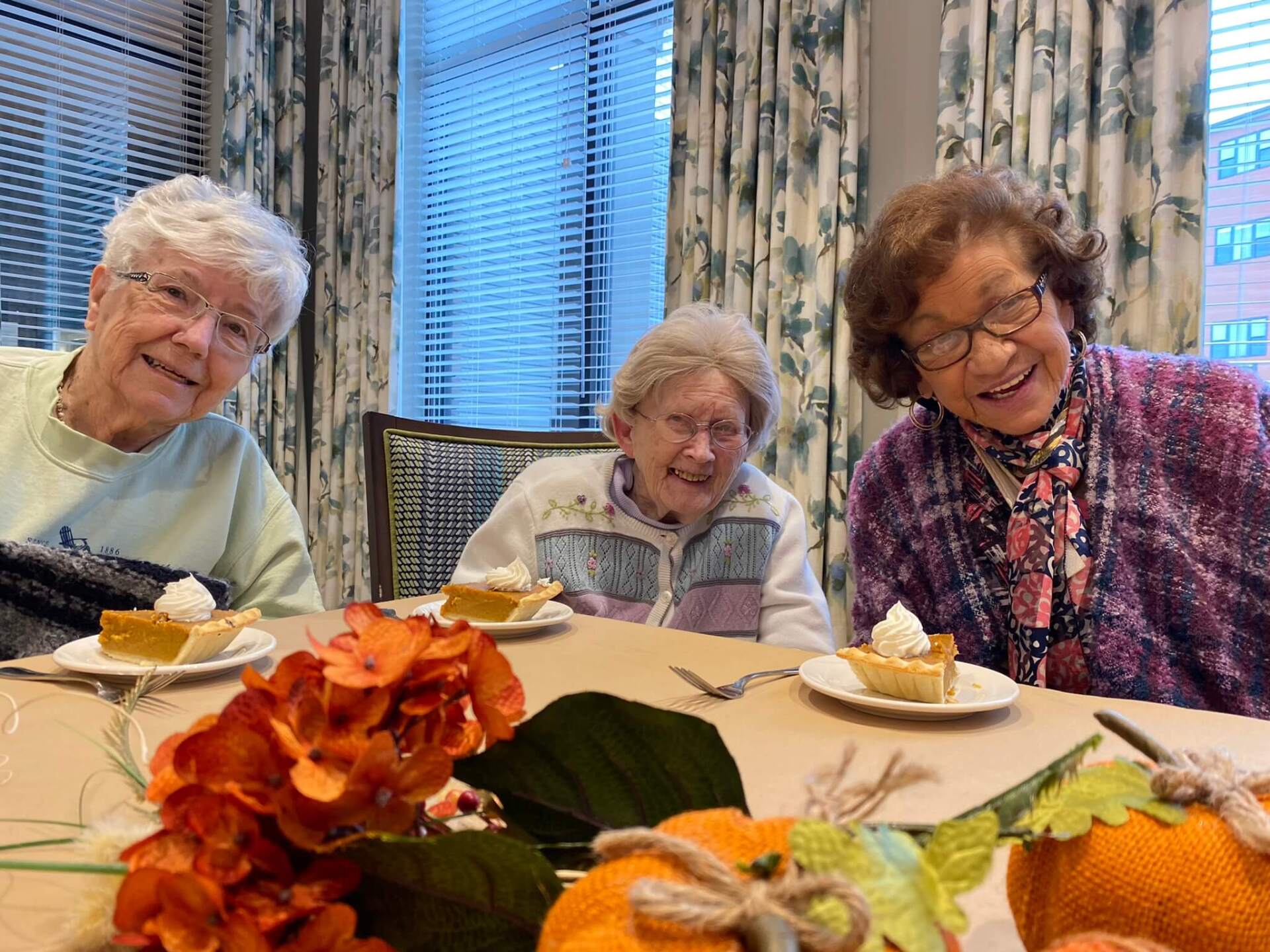 three residents sitting in the newly constructed dining room at Wellspring Living eating pumpkin pie
