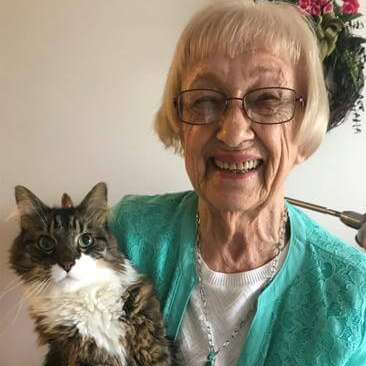 active retiree holding her pet cat in her independent living apartment
