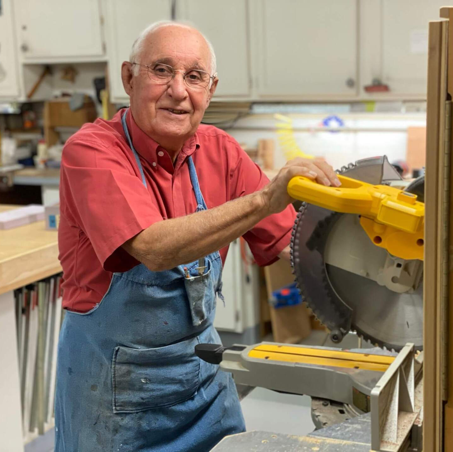independent living resident using a saw in the Landmark Commons woodshop