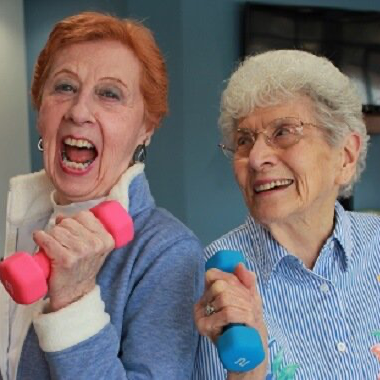 Retired ladies lifting weights during their wellness class at Friendship Village