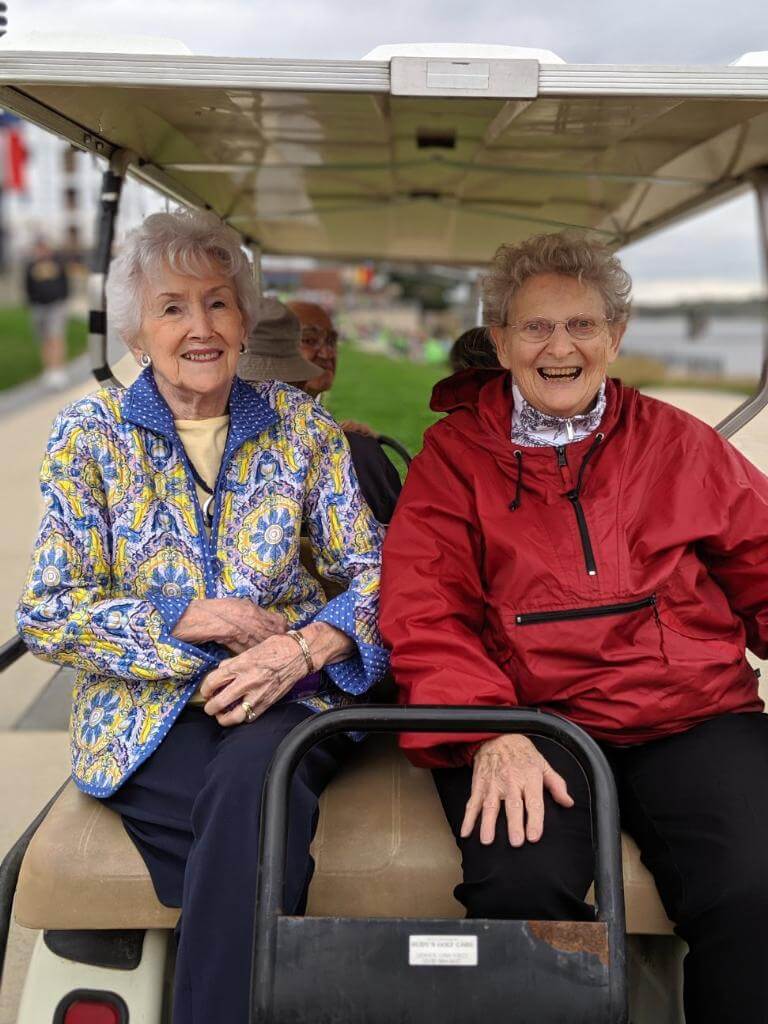 Senior residents riding on the back of a golf cart at the Alzheimer's fundraiser