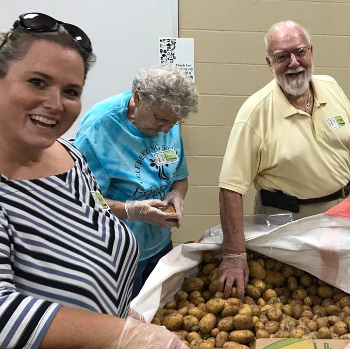employee along side senior residents volunteering at the food bank