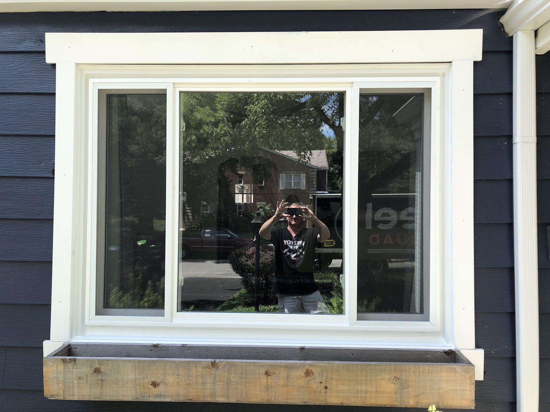 A woman is taking a picture of herself in a window.