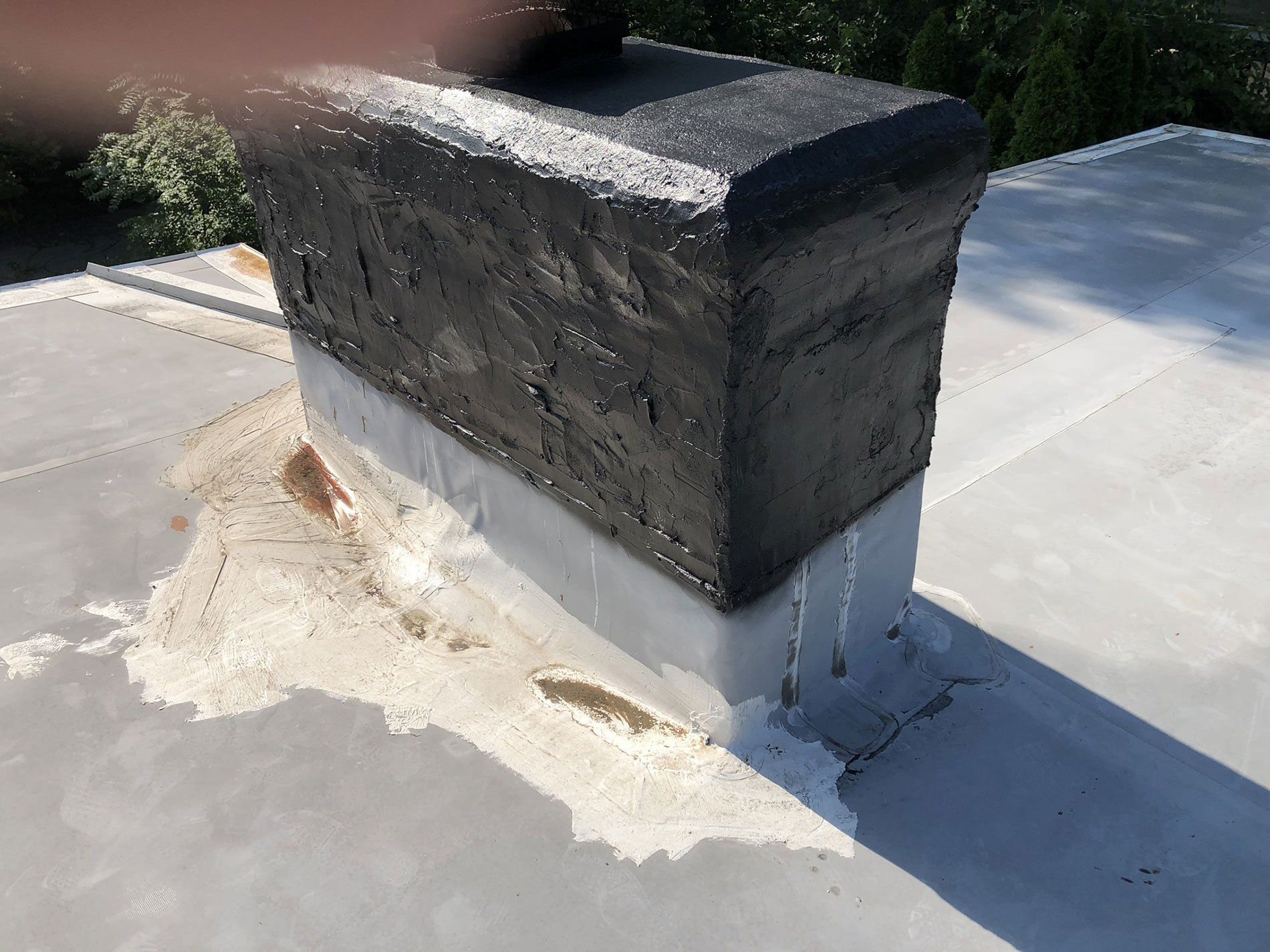 A chimney is sitting on top of a concrete roof.