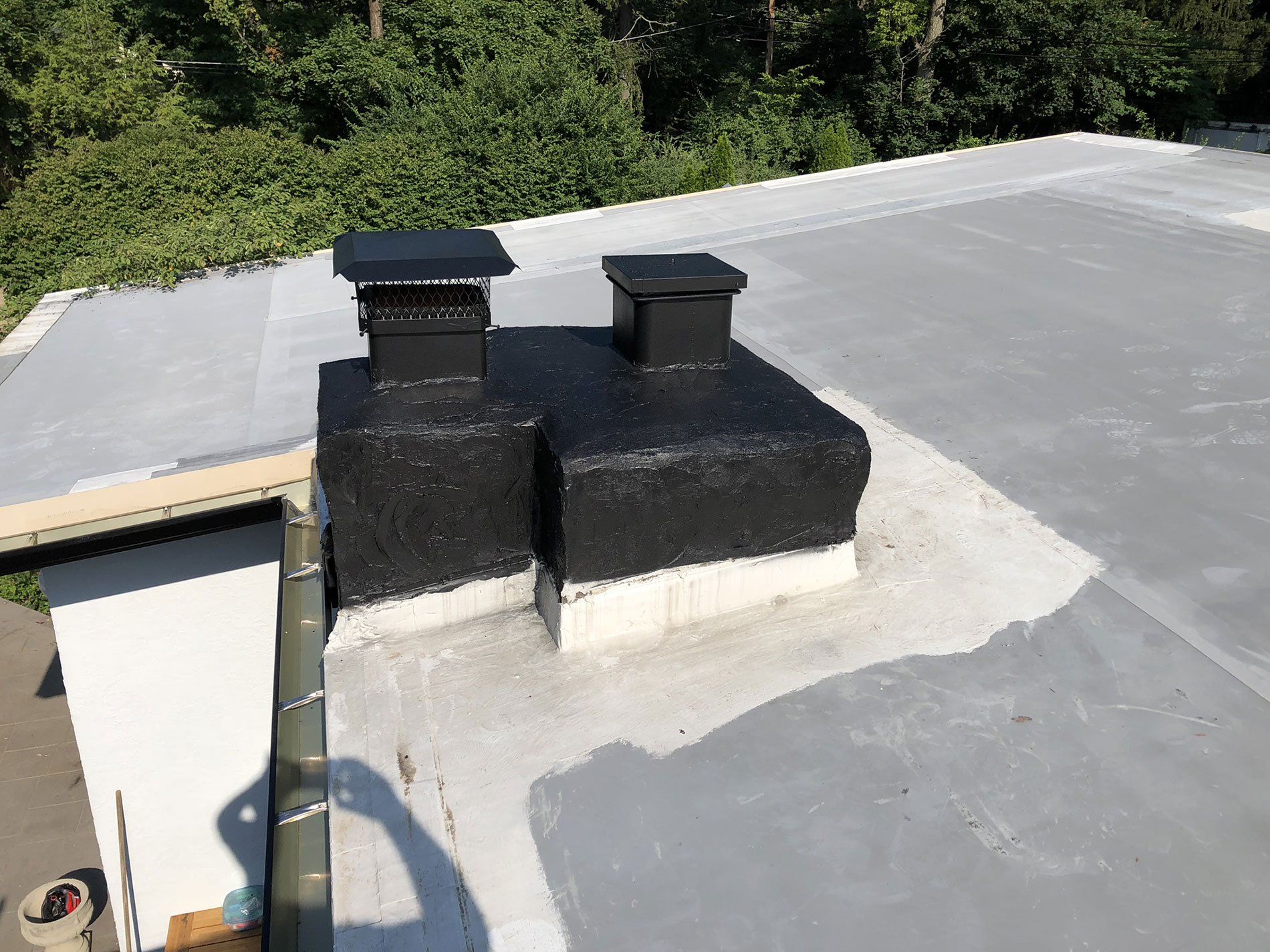 There are two chimneys on the roof of a building.