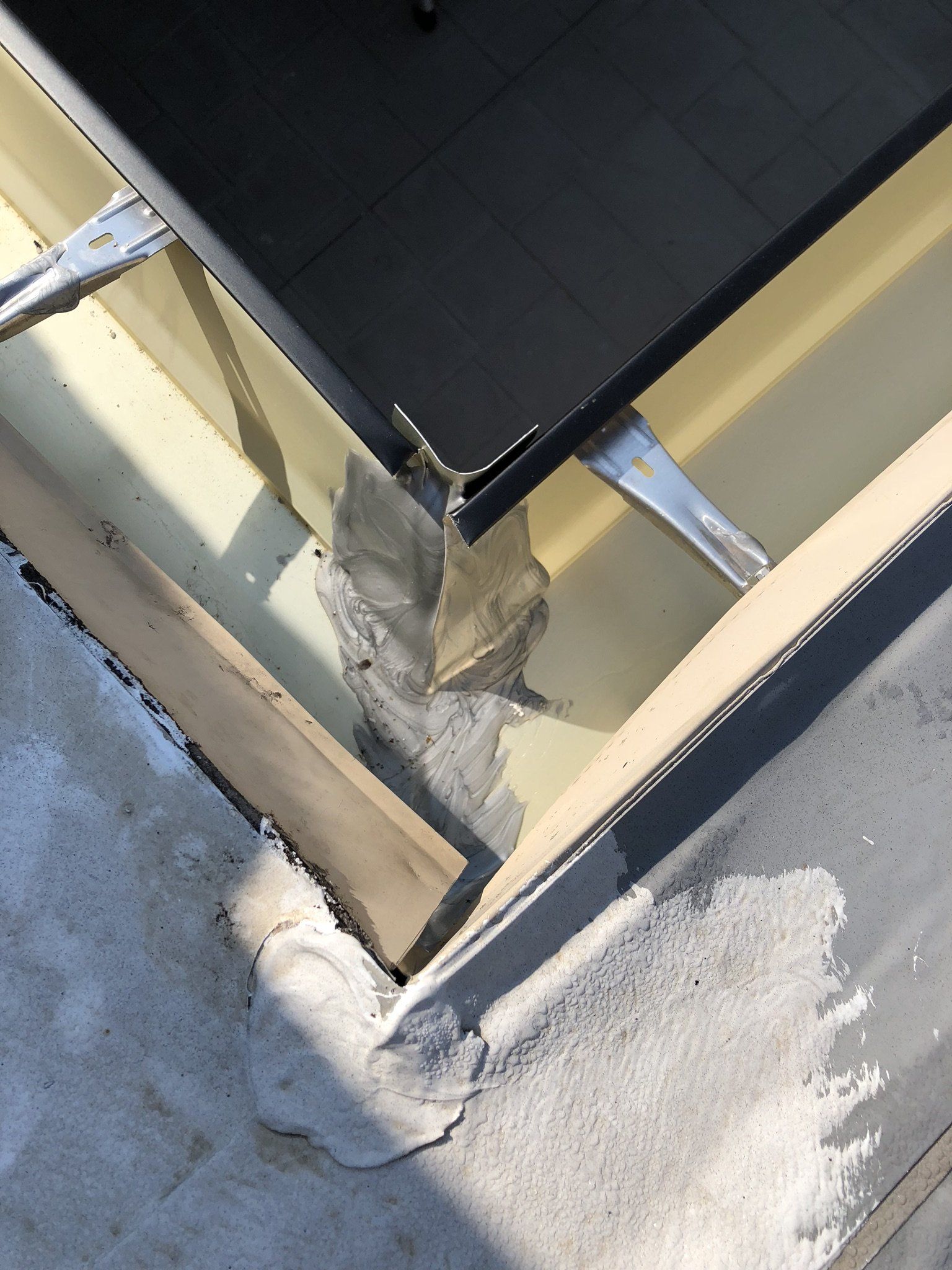 A person is working on a roof with a brush.