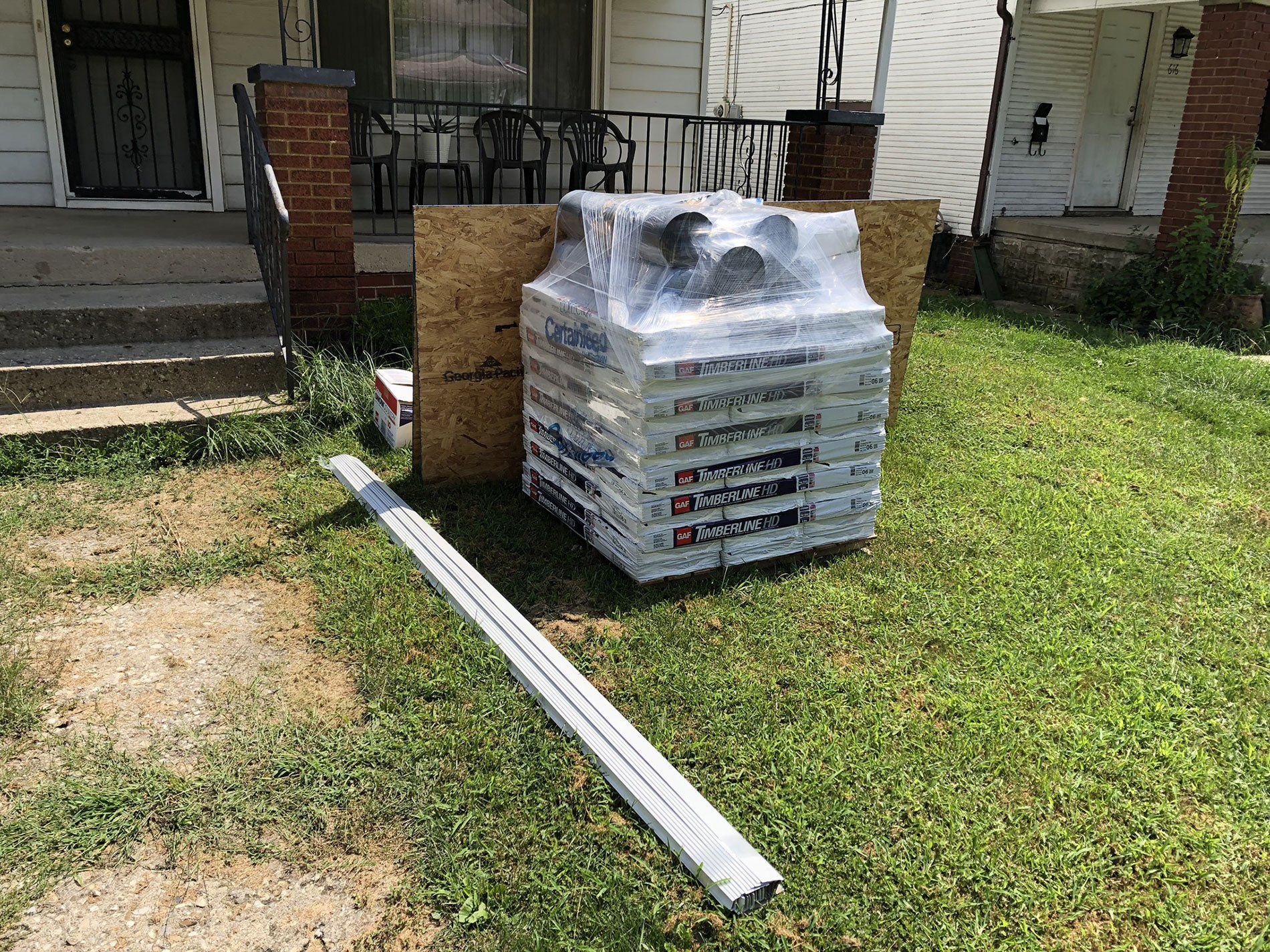 A stack of boxes sitting on top of a lush green lawn in front of a house.