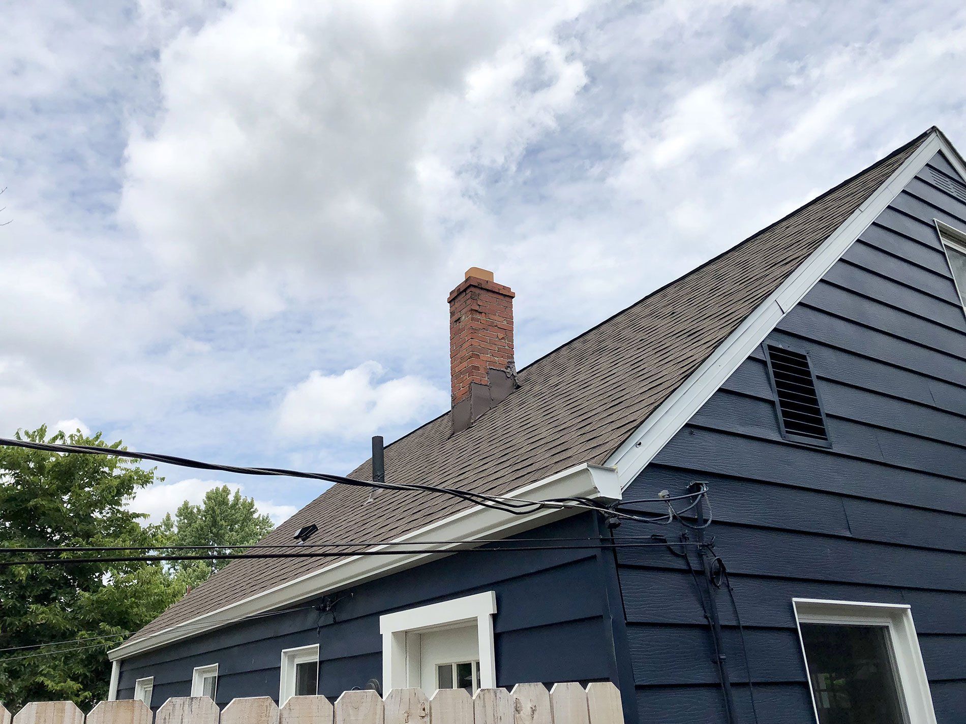 A blue house with a chimney on the roof