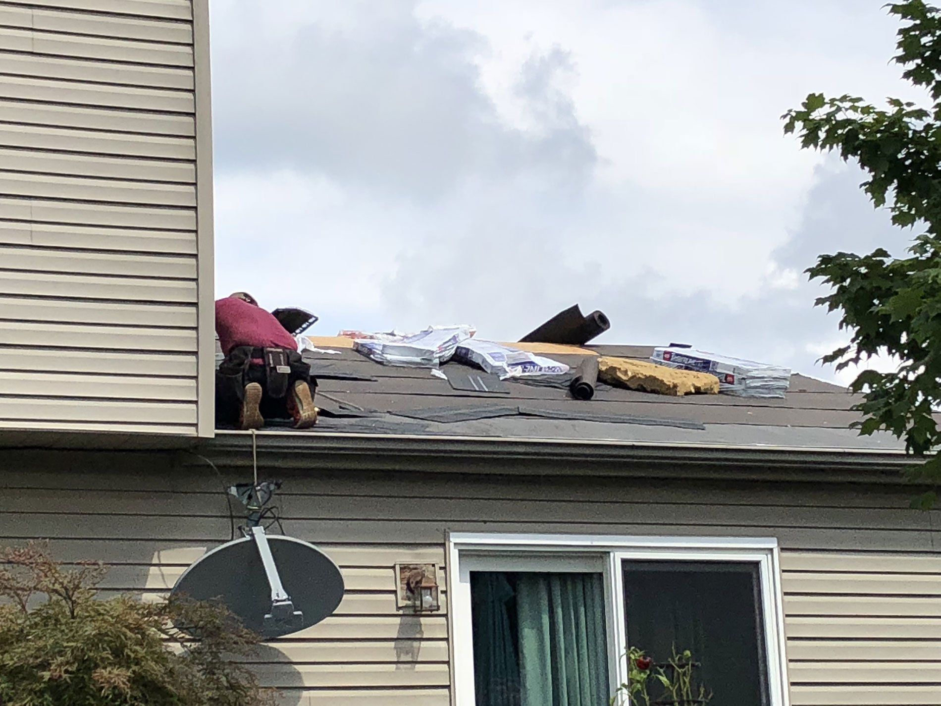 A man is working on the roof of a house.