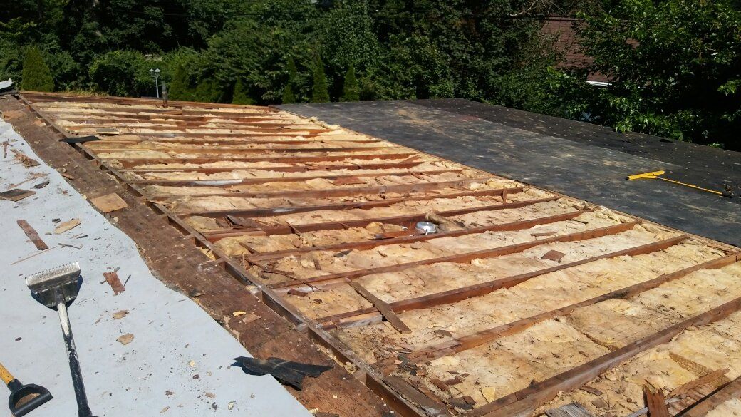 A wooden roof is being removed from a house.