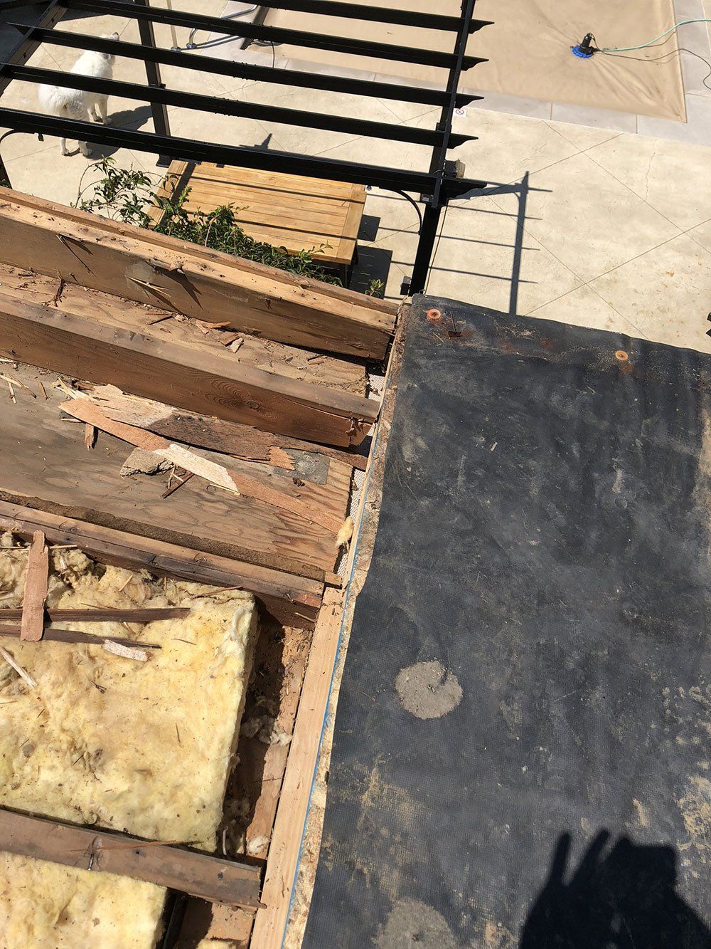 A close up of a wooden structure with a shadow on the ground.