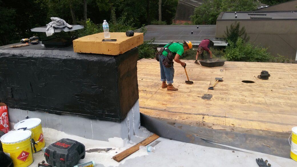 A man is cleaning the roof of a house with a broom.