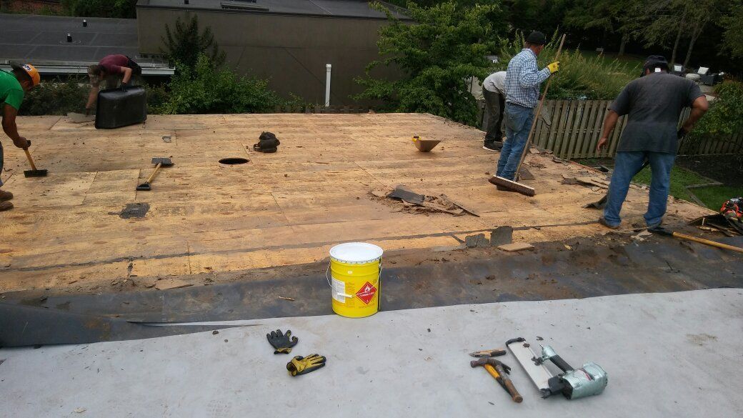 A group of men are working on a roof.