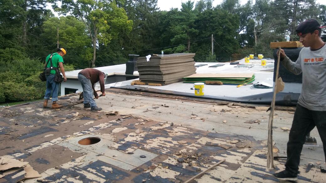 A group of men are working on a roof.
