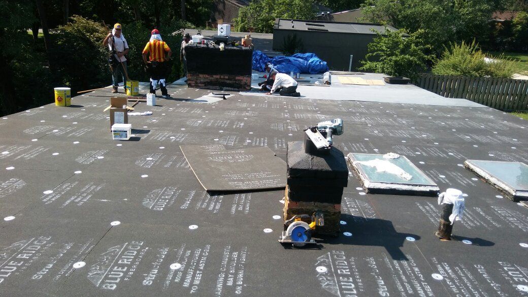 A group of people are working on the roof of a house
