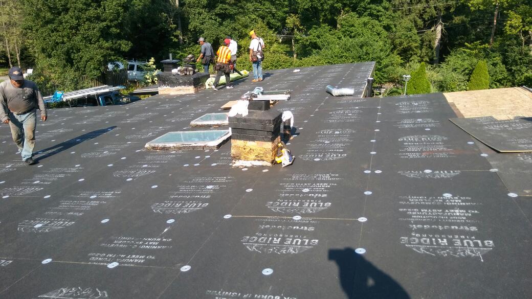 A group of people are working on a roof.