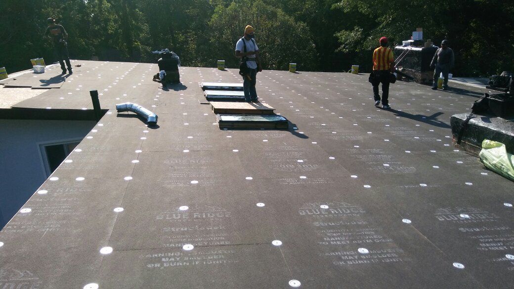A group of people are standing on top of a roof.