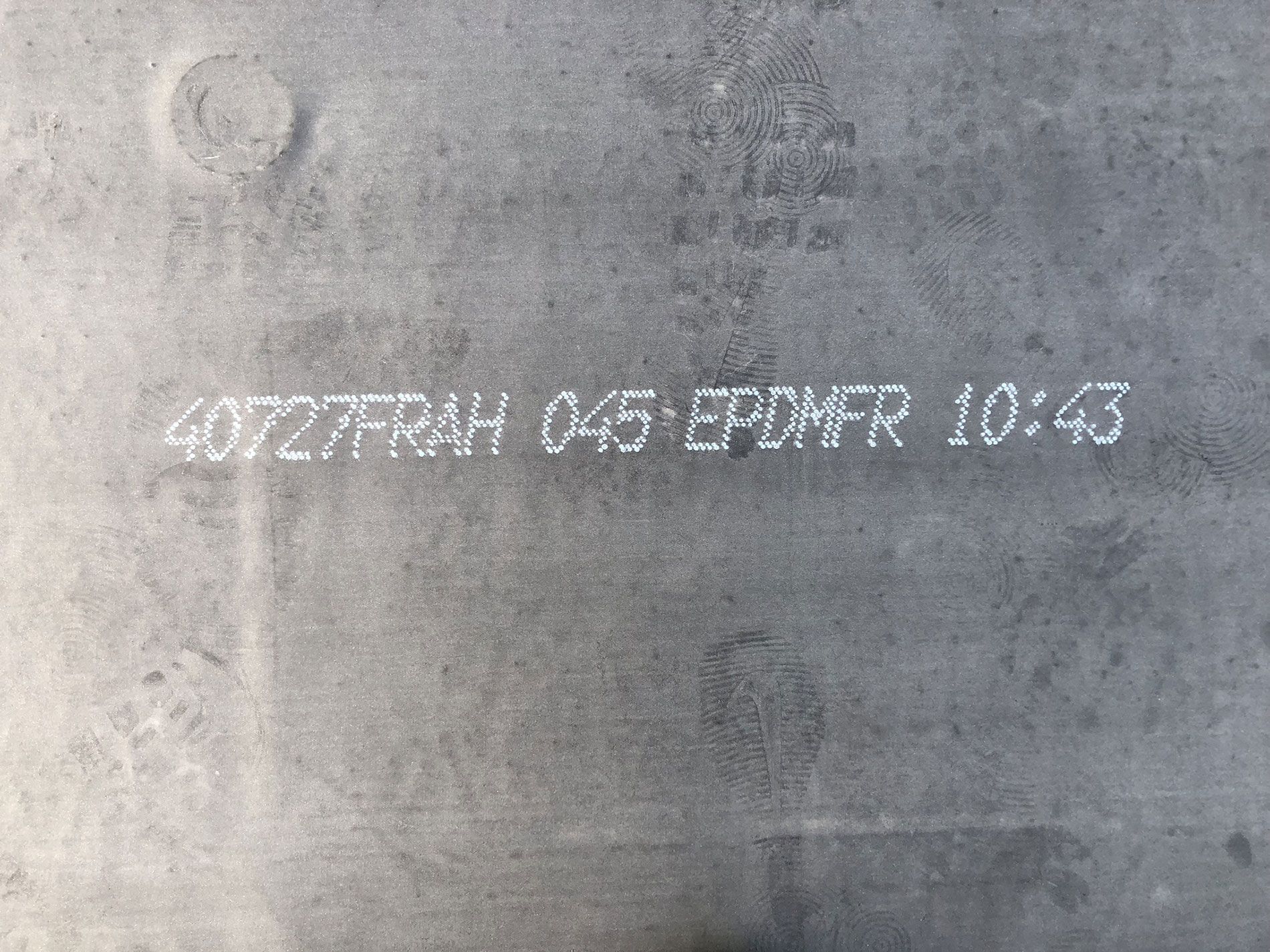 A close up of a piece of metal with the numbers 40727frah 045 epdmfr 10:43 written on it