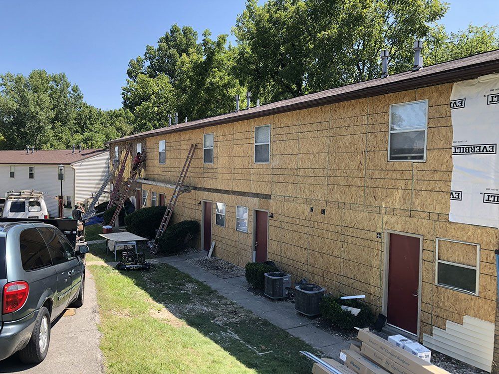 A car is parked in front of a building that is being remodeled.
