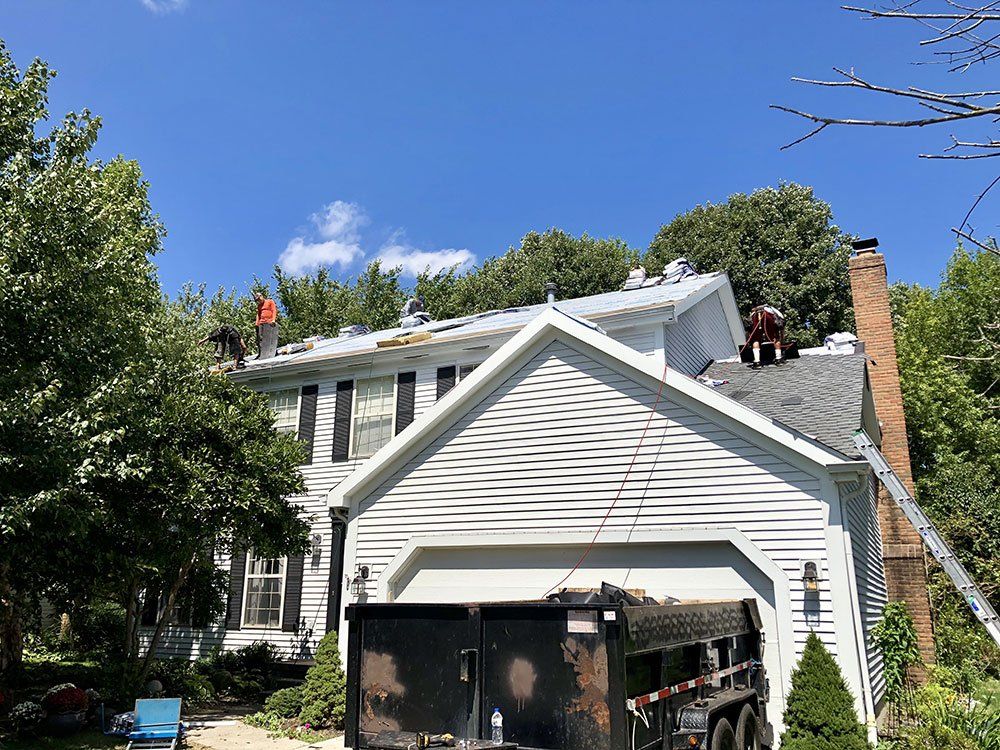 A man is working on the roof of a house.