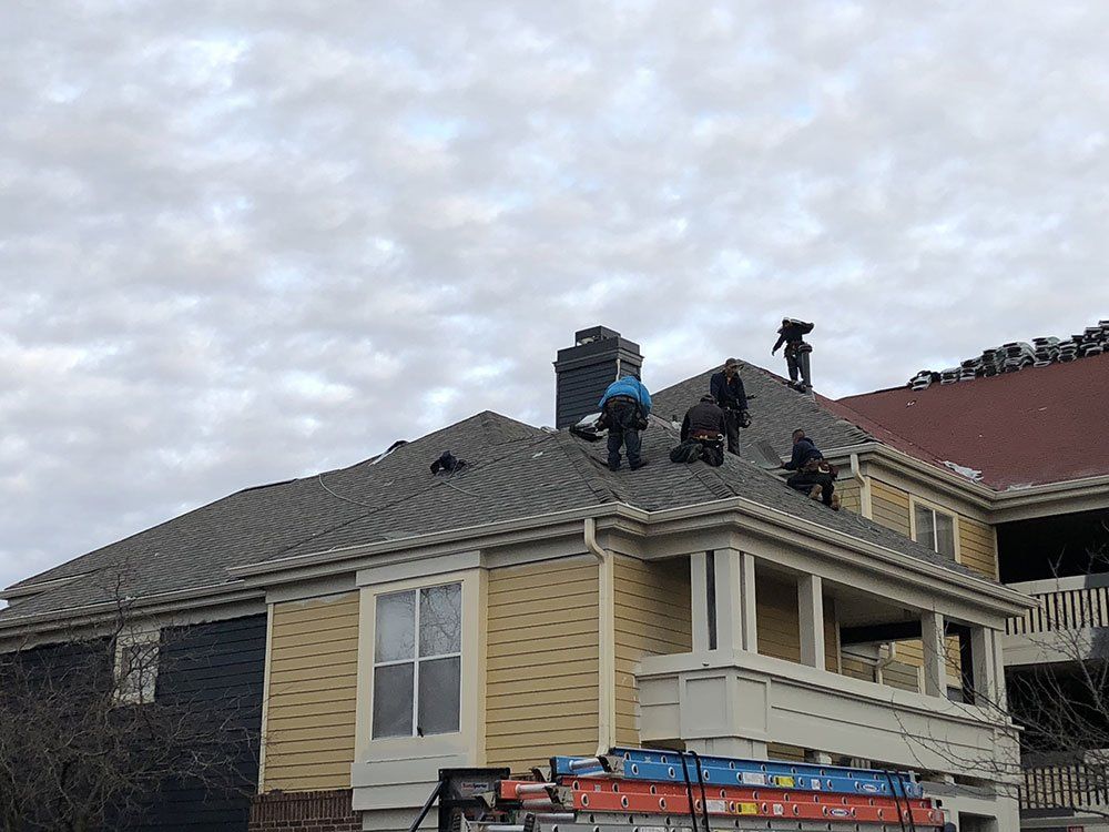 A group of people are working on the roof of a house.