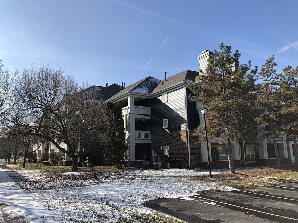 A large building with snow on the ground in front of it