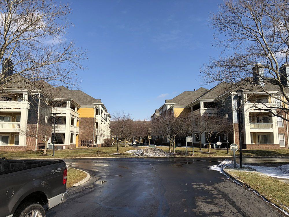 A truck is parked in front of a row of apartment buildings.