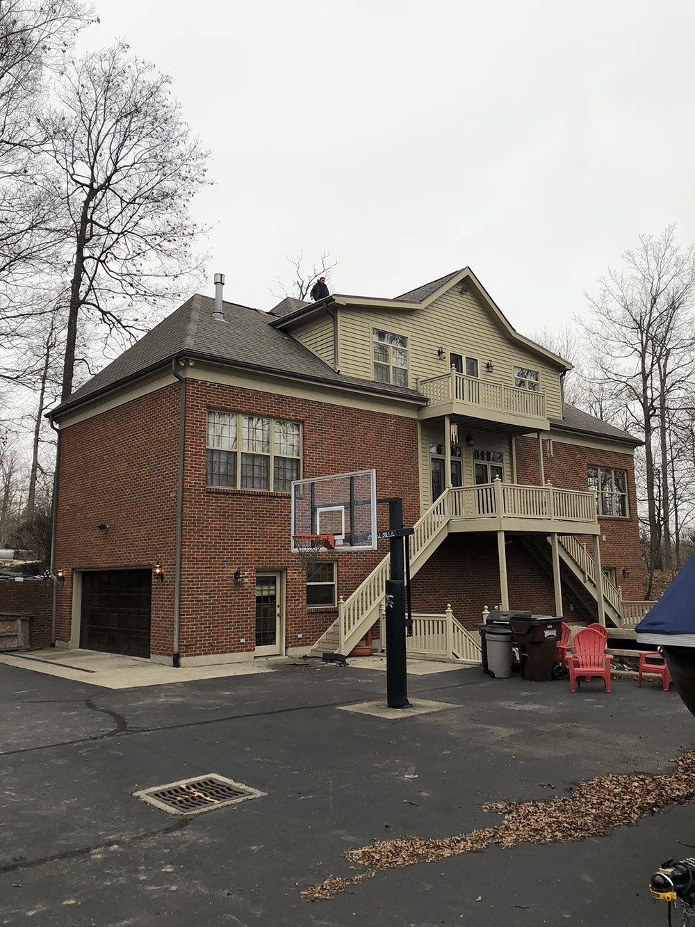 A large brick house with a basketball hoop in the backyard.