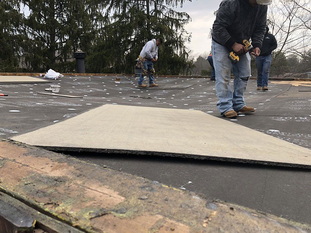 A group of men are working on a roof.